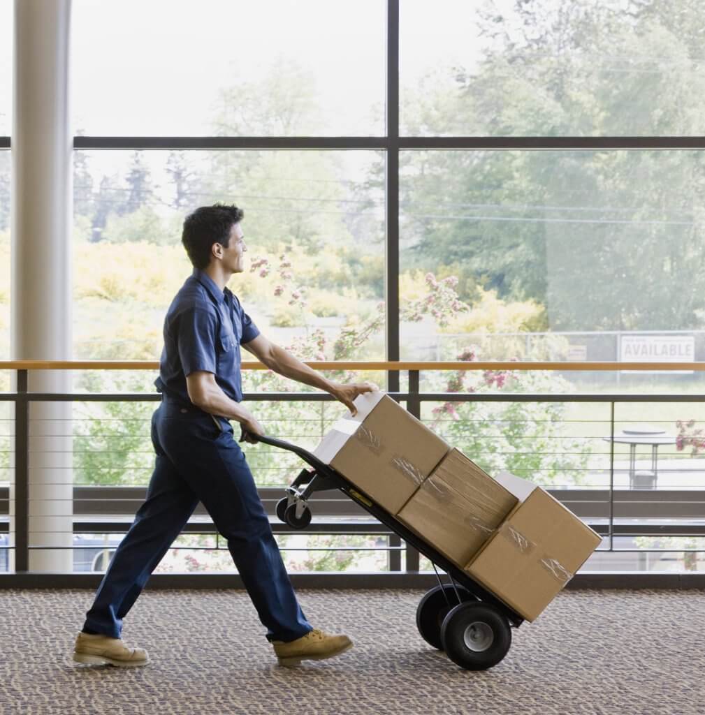 man moving boxes on hand truck