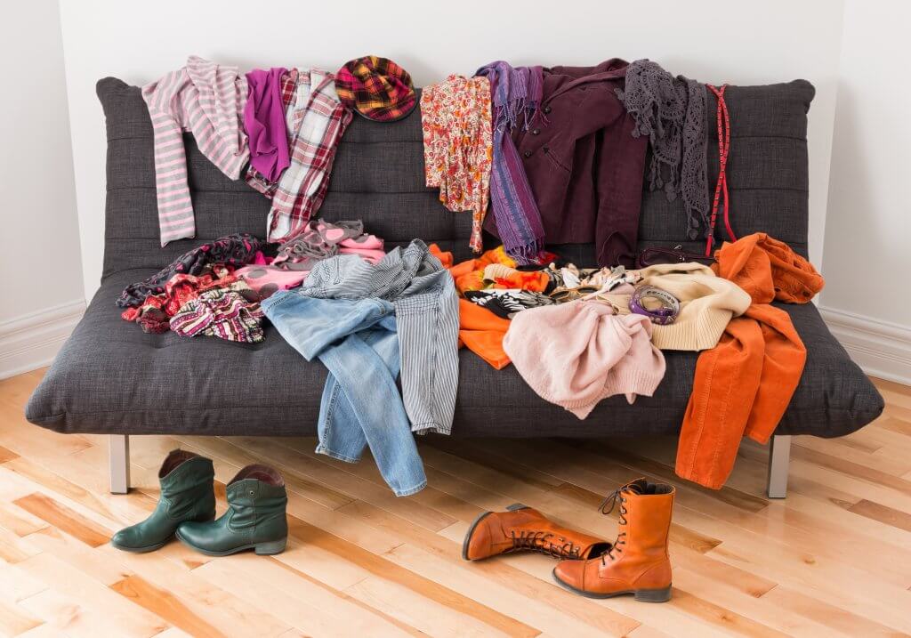 couch covered in clothes