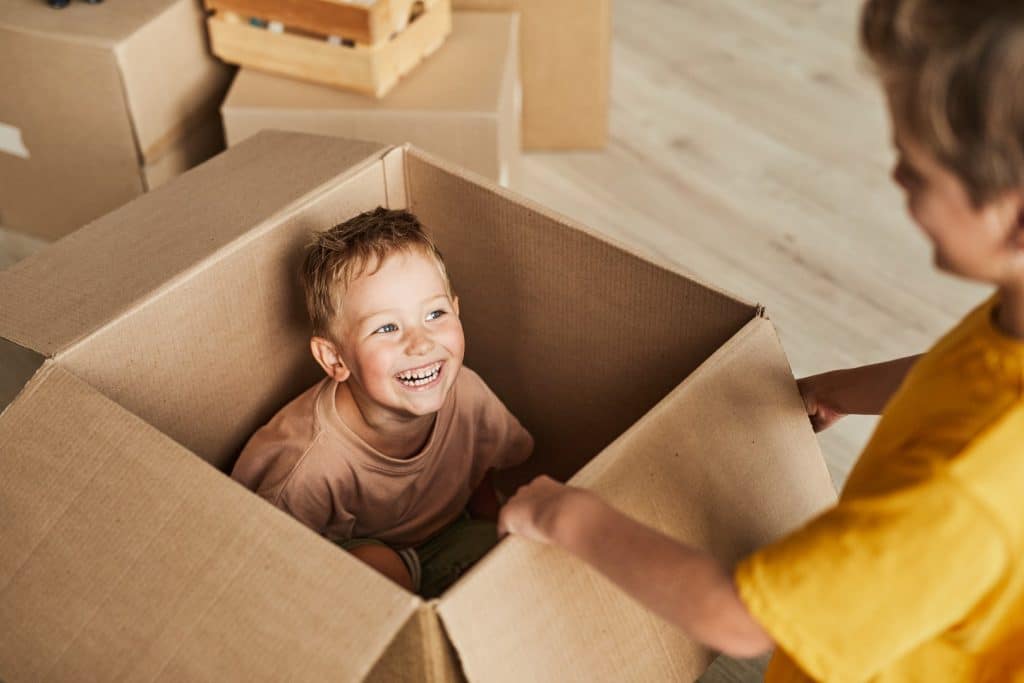 children playing inside cardboard box