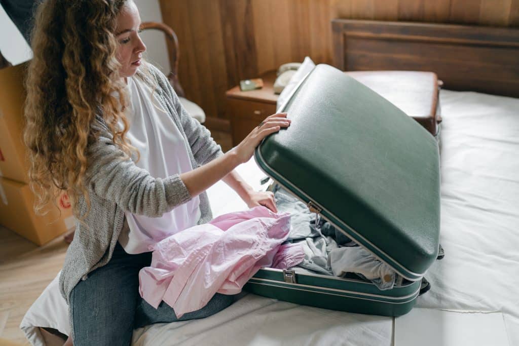 woman packing clothes into a suitcase