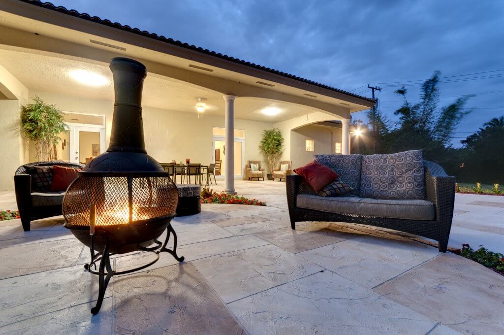 Fire pit in a modern backyard with patio furniture.