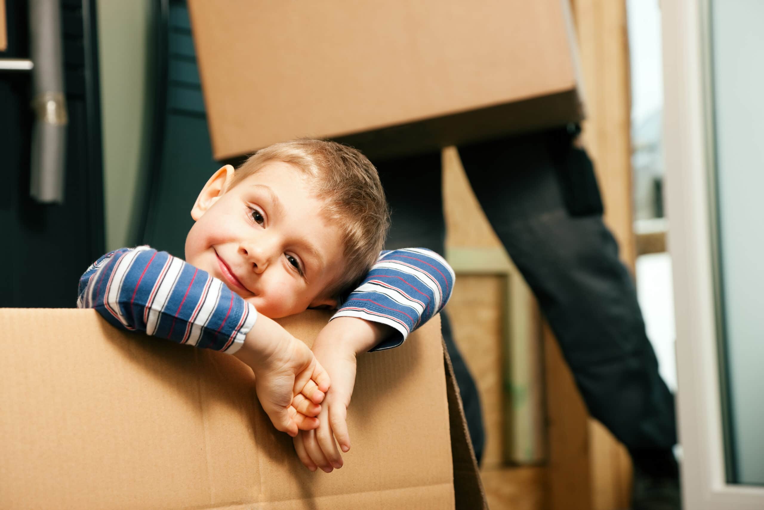 young boy leaning on a box