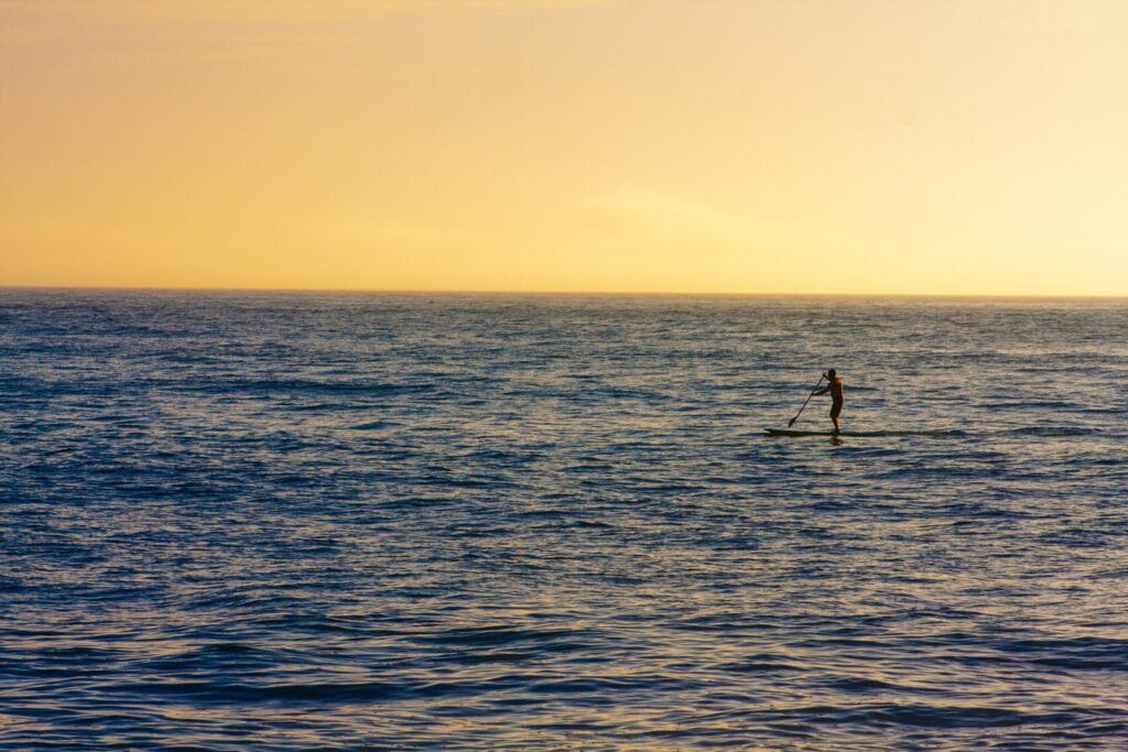 Man paddleboarding in the big blue ocean