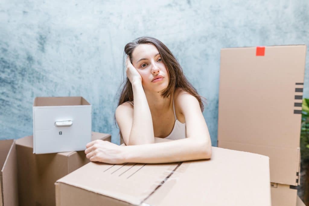 stressed woman surrounded by moving boxes