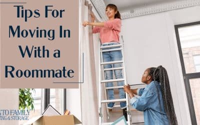 Tips For Moving In With a Roommate - two women hanging curtains in their new apartment