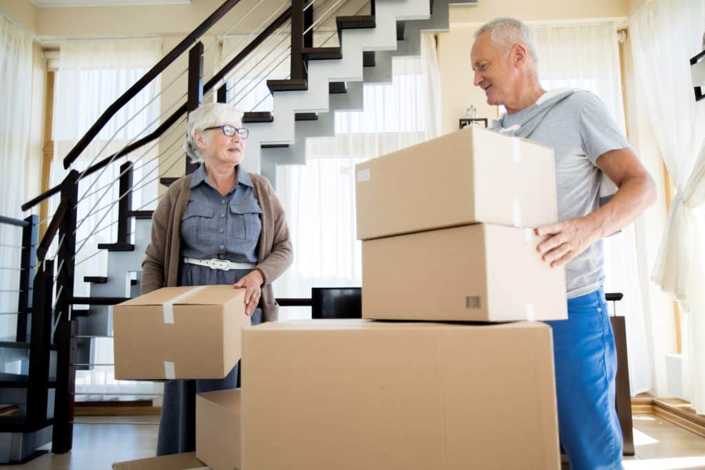 An elderly couple packs up moving boxes